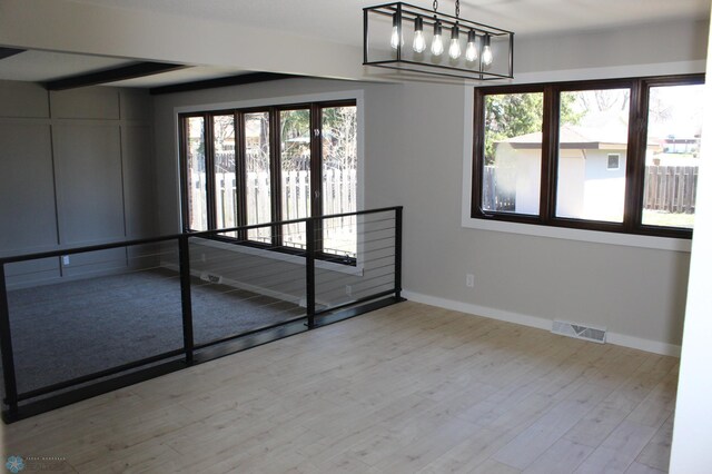 empty room with visible vents, baseboards, and wood finished floors