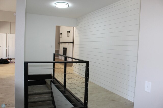 stairway with wood walls and wood finished floors