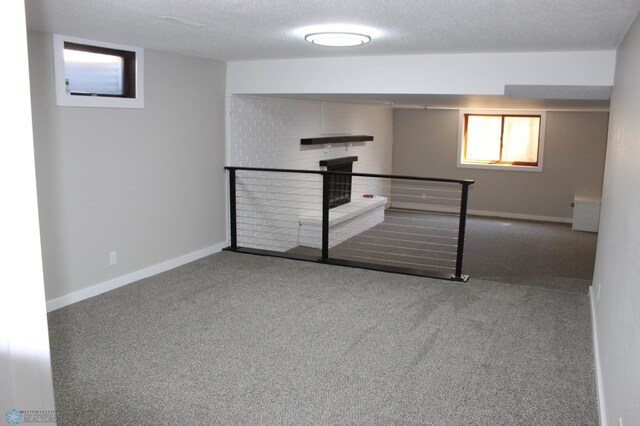 spare room featuring baseboards, carpet, and a textured ceiling