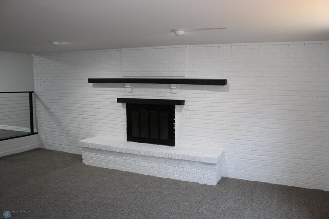 unfurnished living room featuring carpet floors, brick wall, and a brick fireplace