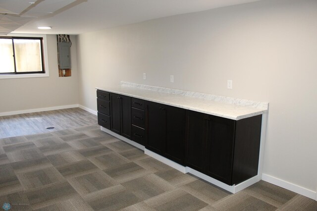 interior space featuring light colored carpet, baseboards, and electric panel
