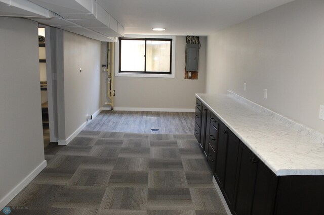 clothes washing area featuring baseboards and electric panel