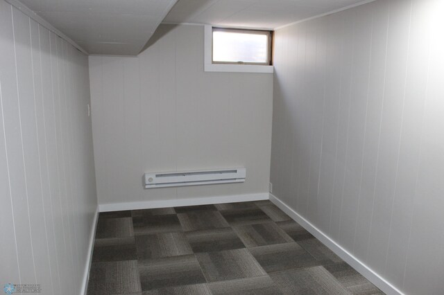 interior space with dark colored carpet and baseboard heating