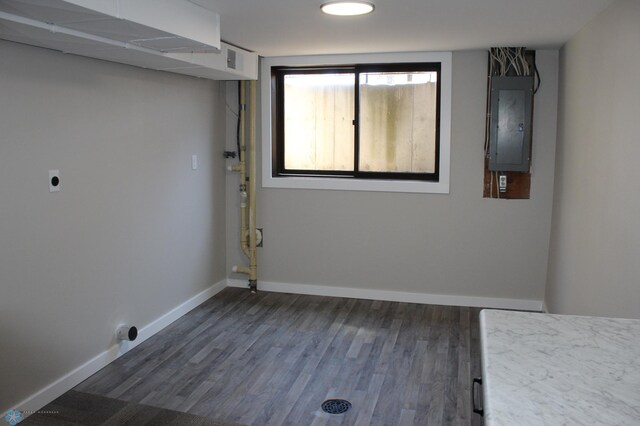 laundry room featuring laundry area, electric panel, electric dryer hookup, dark wood finished floors, and baseboards