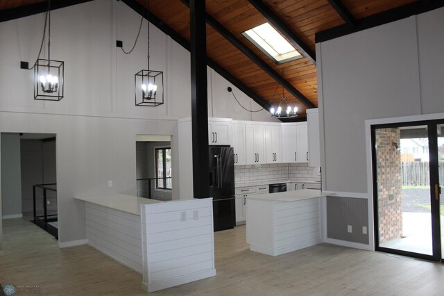 kitchen featuring an inviting chandelier, high vaulted ceiling, a peninsula, wood ceiling, and black appliances