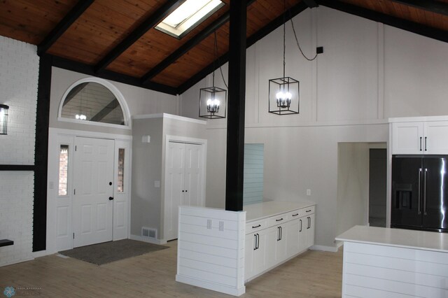 entrance foyer featuring visible vents, high vaulted ceiling, wood ceiling, light wood-style flooring, and a notable chandelier