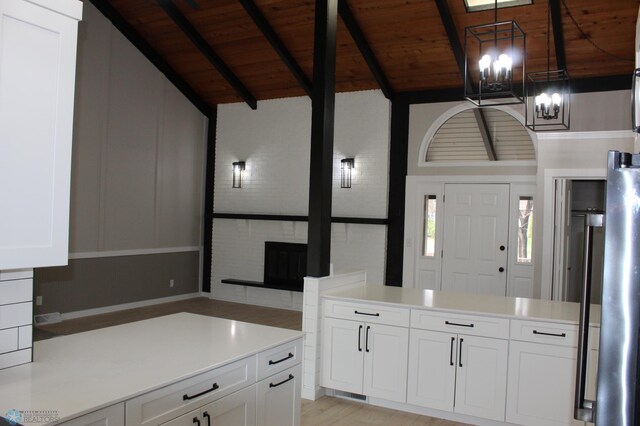 kitchen with light countertops, wood ceiling, a chandelier, white cabinets, and lofted ceiling with beams