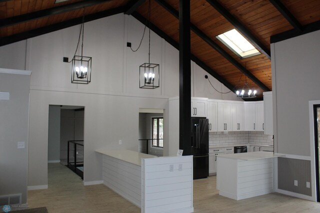 kitchen with visible vents, wooden ceiling, black appliances, a peninsula, and a notable chandelier