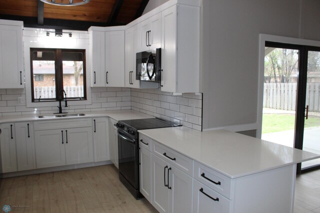 kitchen featuring lofted ceiling with beams, a sink, backsplash, wood ceiling, and black appliances