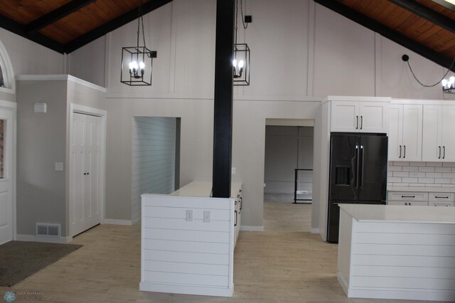 kitchen with wood ceiling, black fridge, high vaulted ceiling, and a chandelier