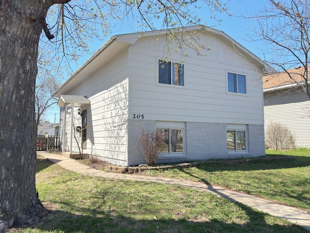 view of side of property featuring a yard and brick siding