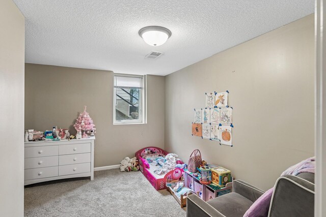 bedroom with carpet floors, baseboards, a textured ceiling, and visible vents