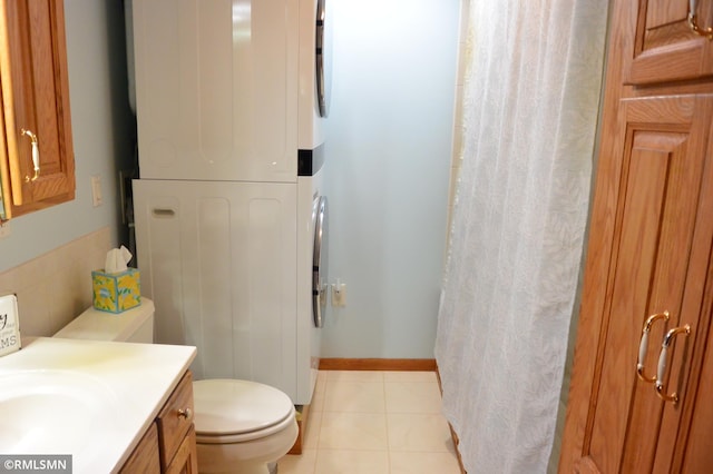 bathroom featuring toilet, vanity, curtained shower, stacked washer and dryer, and tile patterned floors