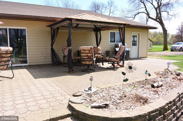 back of house with a gazebo, a patio area, and roof with shingles