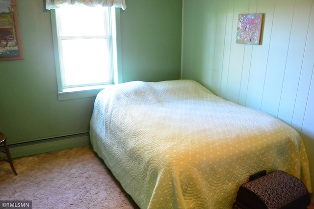 bedroom with carpet floors, baseboard heating, and multiple windows