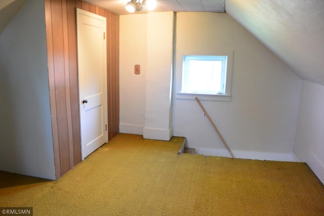 additional living space featuring lofted ceiling and light carpet