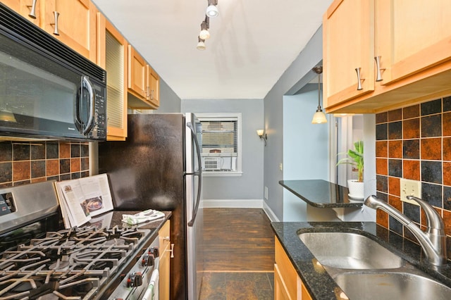 kitchen featuring black microwave, a sink, stainless steel gas stove, baseboards, and decorative backsplash