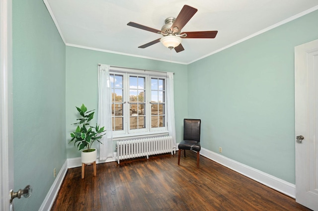 living area featuring a ceiling fan, crown molding, wood finished floors, baseboards, and radiator heating unit