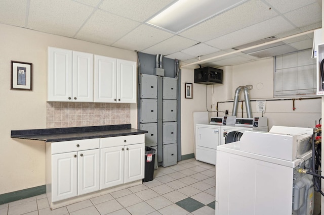 laundry area featuring washer and dryer, baseboards, light tile patterned floors, and cabinet space