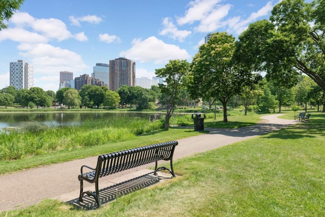 view of community featuring a lawn, a city view, and a water view