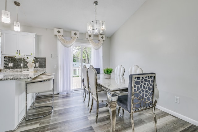 18095 Exeter Pl, Farmington, MN 55024 - dining area featuring light wood-style flooring, a chandelier, and baseboards