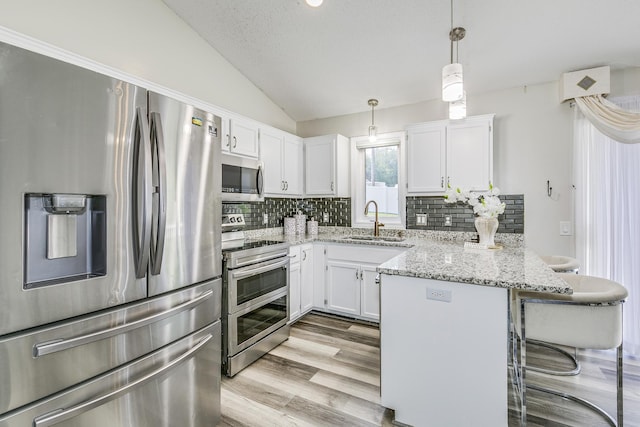 18095 Exeter Pl, Farmington, MN 55024 - kitchen with stainless steel appliances, a sink, a peninsula, a breakfast bar, and white cabinets