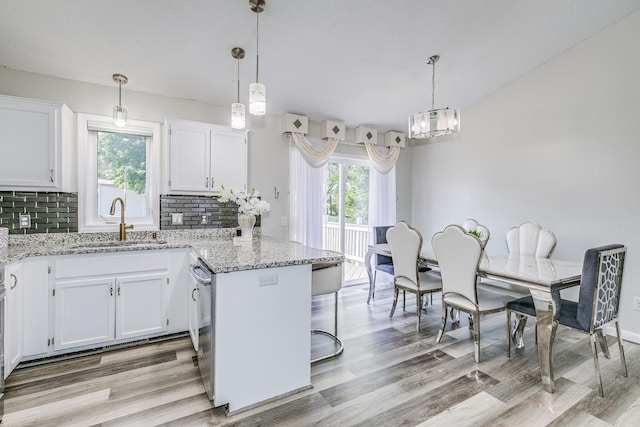 18095 Exeter Pl, Farmington, MN 55024 - kitchen with a sink, a peninsula, decorative backsplash, and white cabinetry