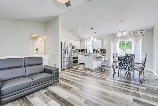 18095 Exeter Pl, Farmington, MN 55024 - living area with light wood-style floors, a chandelier, baseboards, and high vaulted ceiling