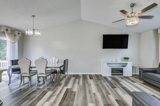 18095 Exeter Pl, Farmington, MN 55024 - dining room with wood finished floors, a chandelier, vaulted ceiling, ceiling fan, and baseboards