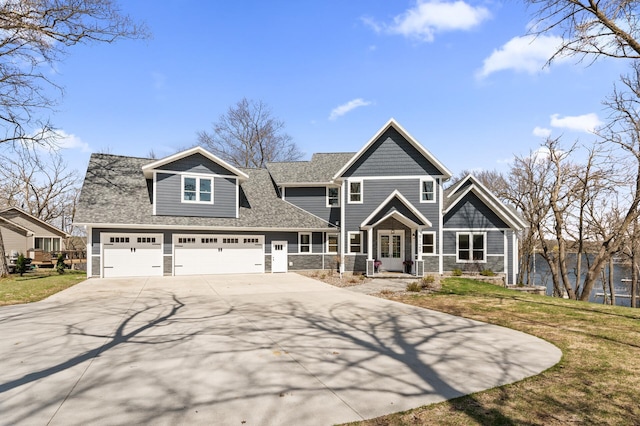 craftsman house with roof with shingles, a front yard, driveway, and stone siding