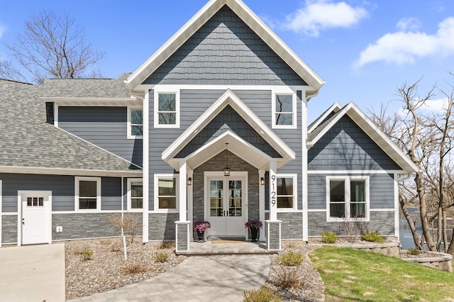 craftsman-style home featuring french doors and stone siding