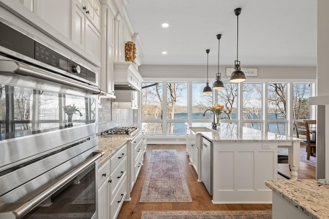 kitchen featuring a water view, white cabinetry, a wealth of natural light, and dark wood-type flooring
