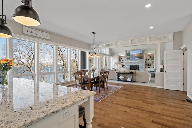 dining area featuring recessed lighting, wood finished floors, and a fireplace