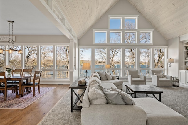 living room featuring high vaulted ceiling, a notable chandelier, and wood finished floors
