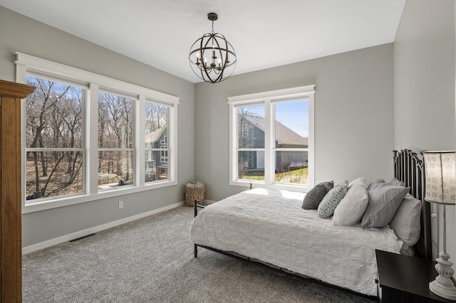 bedroom with baseboards, carpet, a chandelier, and multiple windows
