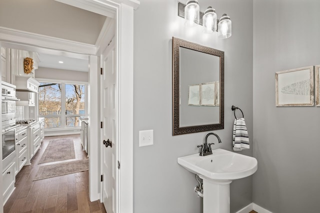 bathroom with baseboards and wood finished floors