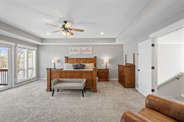bedroom featuring baseboards, light carpet, a tray ceiling, and access to exterior