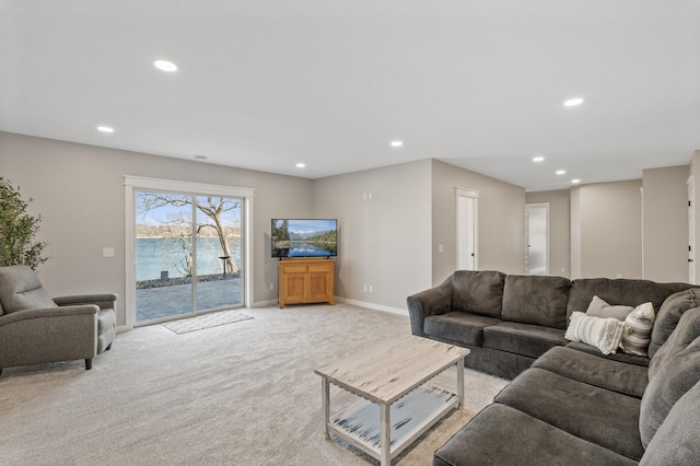 living area featuring baseboards, light carpet, and recessed lighting