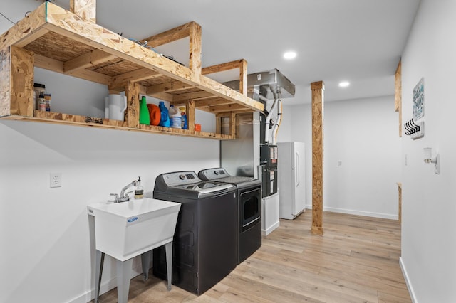 laundry room with laundry area, baseboards, light wood finished floors, separate washer and dryer, and recessed lighting