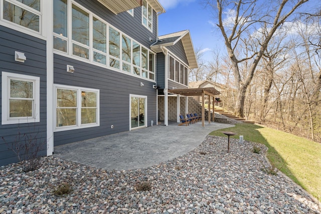 rear view of house featuring stairs and a patio area