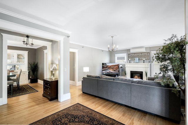 1909 Fremont Ave S Unit 201, Minneapolis, MN 55403 - living room with a chandelier, light wood finished floors, ornamental molding, a glass covered fireplace, and baseboards