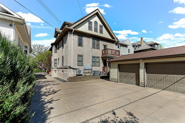 1909 Fremont Ave S Unit 201, Minneapolis, MN 55403 - view of property exterior with cooling unit, an outdoor structure, stucco siding, and a garage