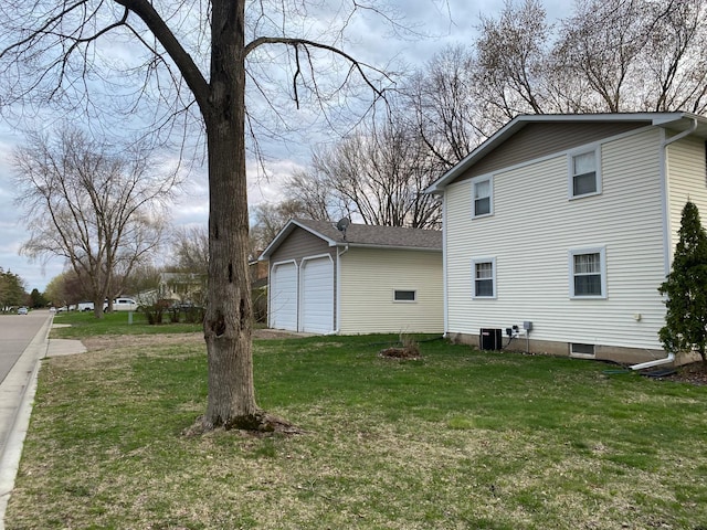 view of property exterior featuring a detached garage, a yard, and central AC