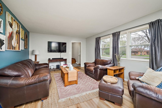 living area with baseboards and wood finished floors