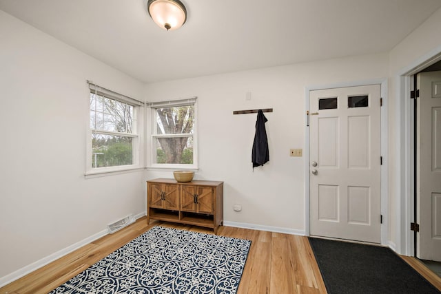 interior space featuring baseboards, wood finished floors, and visible vents