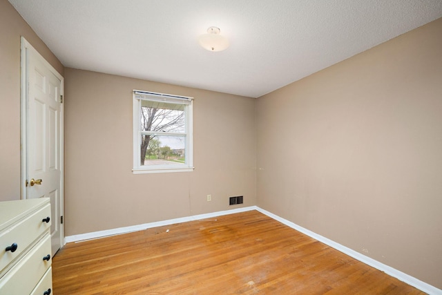 unfurnished bedroom with baseboards, light wood-type flooring, and visible vents