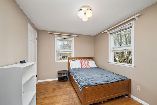 bedroom featuring baseboards and wood finished floors