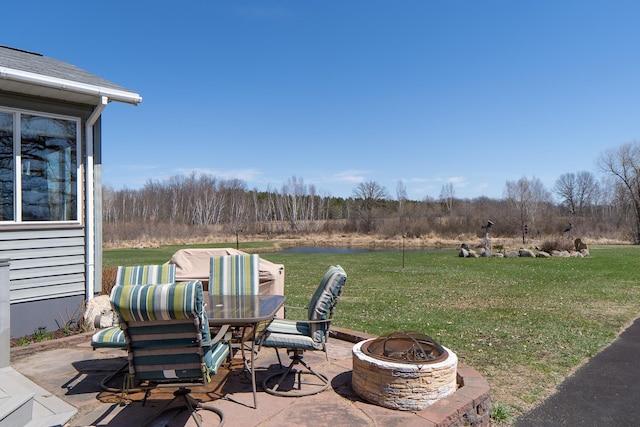 view of patio / terrace featuring an outdoor fire pit, a water view, and outdoor dining space
