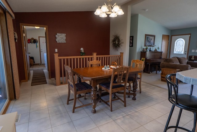 dining space with light tile patterned floors, vaulted ceiling, and a notable chandelier
