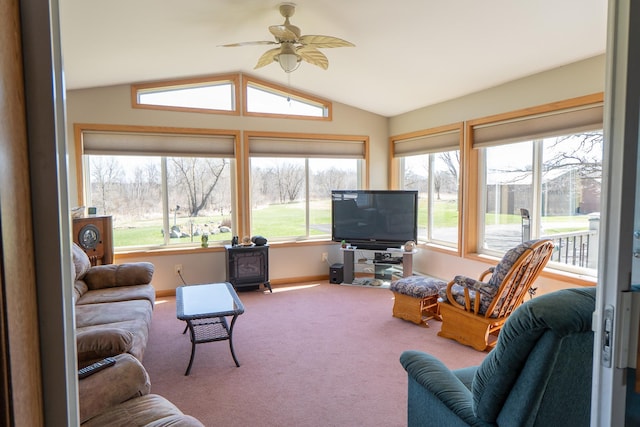 carpeted living room with a ceiling fan, baseboards, and lofted ceiling